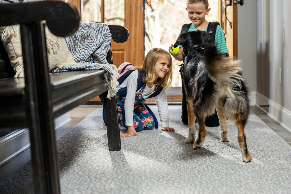 Kids plying with dog on carpet flooring | Direct Carpet Unlimited